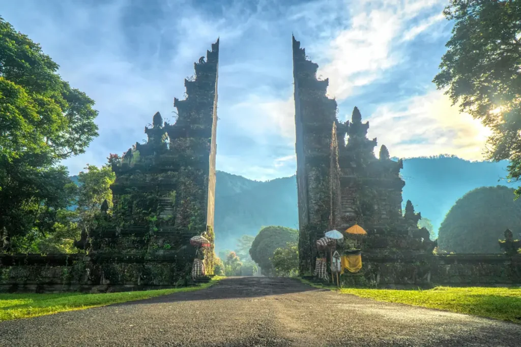 A scenic view of a traditional Balinese stone gate in a lush landscape representing luxurious budget travel 2025 destinations