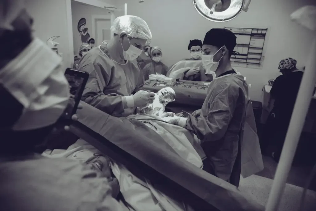 A medical team delivering a newborn baby in an operating room during a complex childbirth procedure.