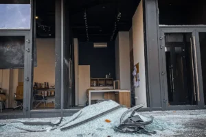Destroyed storefront with shattered glass, illustrating commercial property risks often covered in captive insurance news.