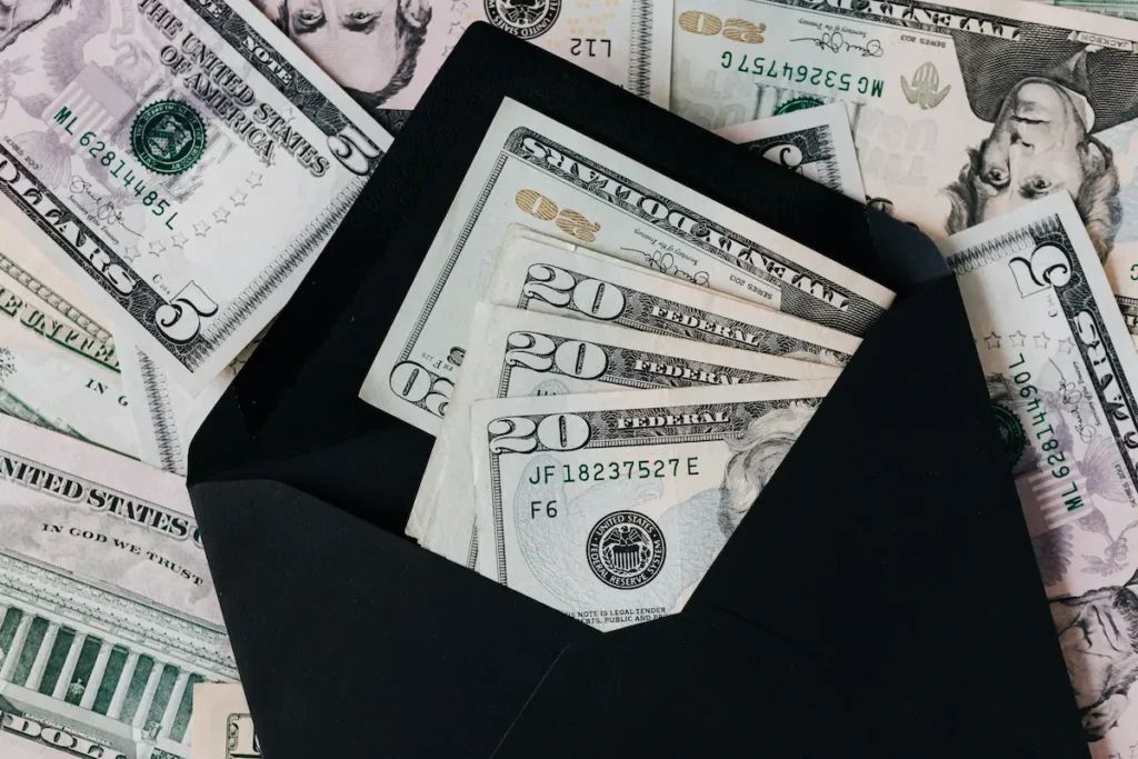 US dollar bills in a black envelope representing a payout managed by a business interruption insurance claim lawyer